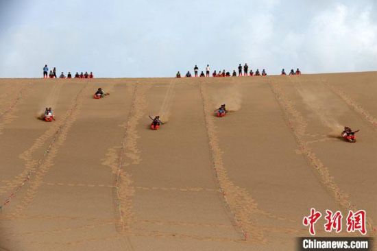 6月13日，敦煌鳴沙山月牙泉景區(qū)舉辦滑沙比賽。　張曉亮 攝