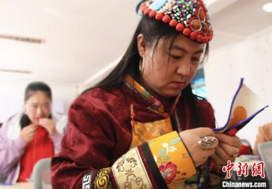 圖為裕固族婦女學(xué)習(xí)刺繡?！∈缝o靜 攝