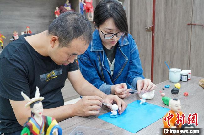 <a target='_blank'  data-cke-saved- >中新社</a>記者(右)現(xiàn)場體驗(yàn)面塑制作過程?！￡悹帍?qiáng) 攝