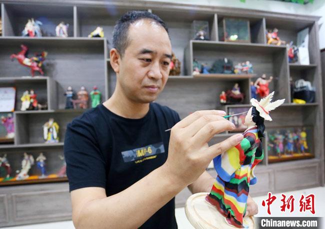 圖為安秋平正在創(chuàng)作代表隴南文縣民俗的《白馬人》作品?！「哒?攝