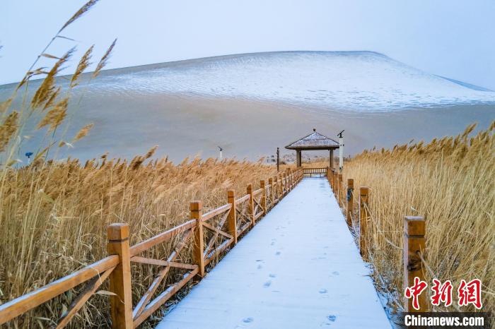 2021年11月28日，在敦煌鳴沙山月牙泉景區(qū)，沙雪交融，更顯北國風(fēng)情?！⊥醣筱y 攝