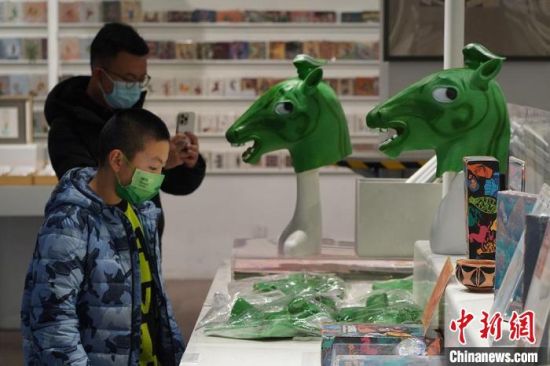圖為“神馬來(lái)了”銅奔馬頭套吸引參觀者駐足。　九美旦增 攝
