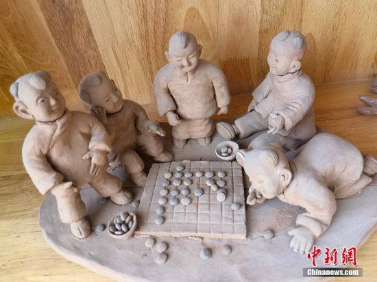 圖為泥塑作品展現(xiàn)下棋場(chǎng)景。 劉玉桃 攝
