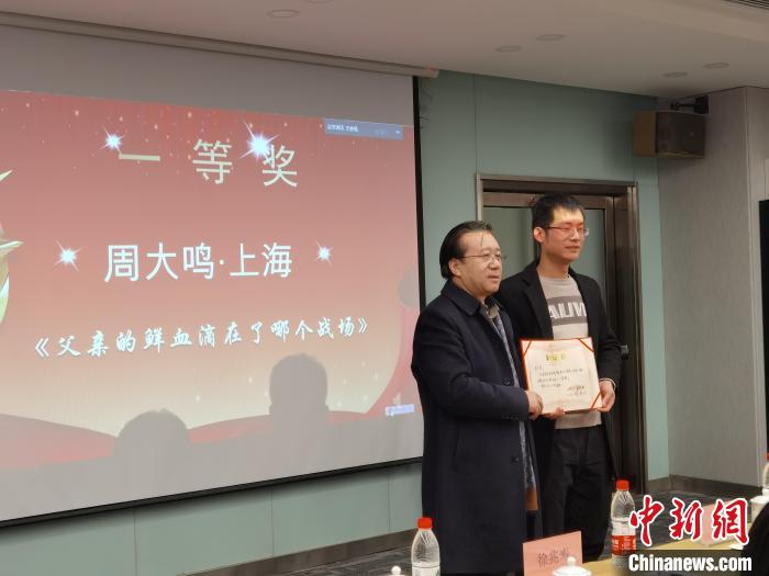 圖為作家、西北師范大學(xué)新聞與傳媒學(xué)院院長徐兆壽頒發(fā)一等獎證書，代領(lǐng)獎?wù)呱吓_領(lǐng)獎?！钅?攝