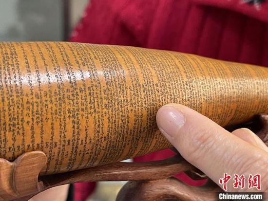 圖為長約二十公分的長條葫蘆雕刻佛教經(jīng)文作品?！堟?攝
