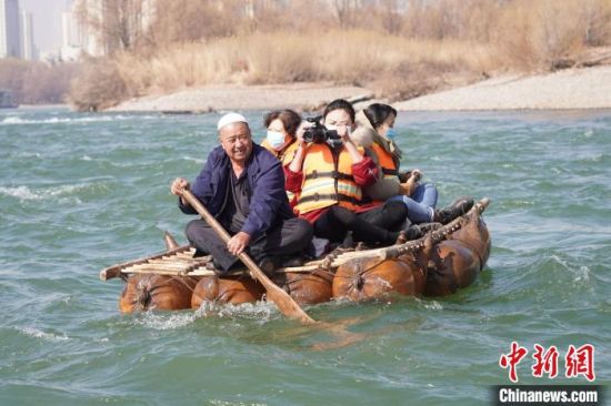 2月24日，年過(guò)七旬的蘭州羊皮筏子制作技藝第三代傳承人張德寶在黃河上劃著羊皮筏子。(資料圖) 九美旦增 攝