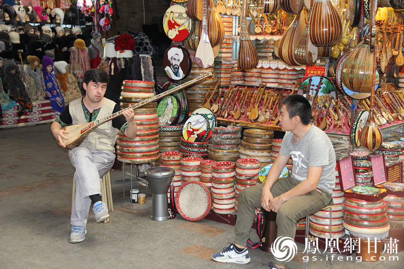 烏魯木齊二道橋巴扎內(nèi)，店主正在向客人展示樂器。楊文遠 攝