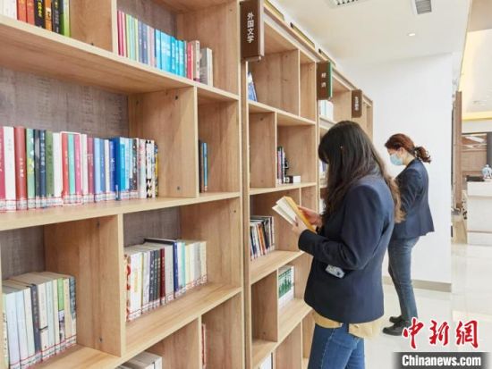圖為在甘肅公航旅建設(shè)集團(tuán)有限公司的職工書屋，職工挑選書籍?！⌒煅?攝