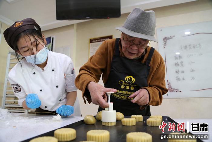 當(dāng)日，受邀參加活動(dòng)的臺(tái)胞臺(tái)屬代表、兩岸婚姻及子女、在甘臺(tái)商代表等歡聚一堂。圖為77歲的在甘臺(tái)胞潘天鑒制作月餅。九美旦增 攝