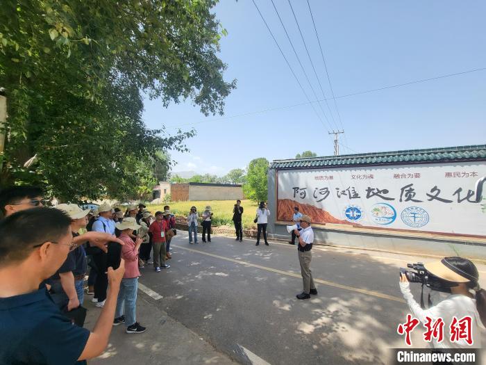 圖為中國地質(zhì)大學(xué)(北京)教授張緒教介紹村落情況?！『衍?攝