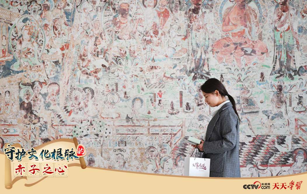 2023年4月25日，敦煌研究院文物數(shù)字化保護(hù)團(tuán)隊創(chuàng)意營銷人員廖雪婷從一幅高保真復(fù)制壁畫前走過。