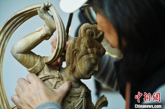 圖為季茂杰進(jìn)行敦煌元素的木雕創(chuàng)作。李亞龍 攝</p>
<p>