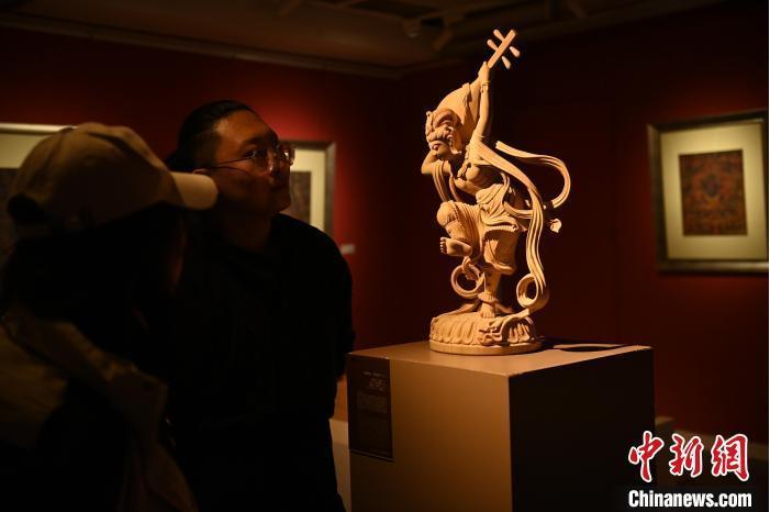 圖為季茂杰向參觀者介紹自己創(chuàng)作敦煌木雕的過程。李亞龍 攝</p>
<p>