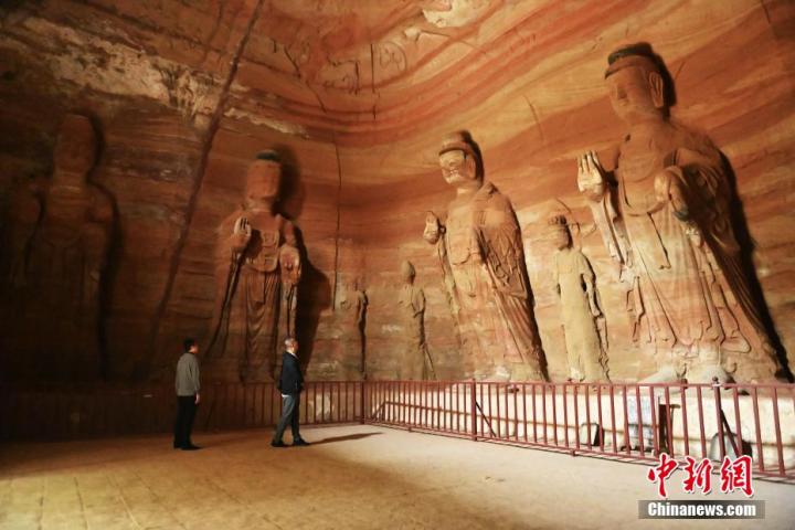 7月15日，游人參觀甘肅省平?jīng)鍪袥艽h百里石窟長廊中的南石窟寺1號窟。百里石窟長廊位于涇川縣境內(nèi)，由512個(gè)石窟、5眼窟中石井組成，現(xiàn)存王母宮石窟、鳳凰山石窟、南石窟寺、丈八寺石窟、羅漢洞石窟、太山寺石窟等規(guī)模較大的石窟群，還有數(shù)量眾多的小石窟群。南石窟寺開鑿于北魏永平三年，其中1號窟屬于大型七佛窟，七佛高達(dá)6米。中新社記者 李亞龍 攝